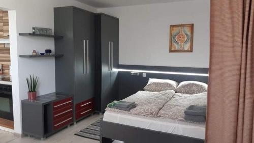 科马尔诺Szoba konyha lakas的一间卧室配有一张带黑色床头板的床