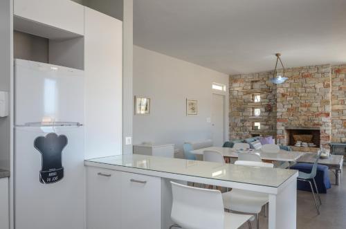 米科利维亚Sunshine villa的厨房配有桌椅和砖墙