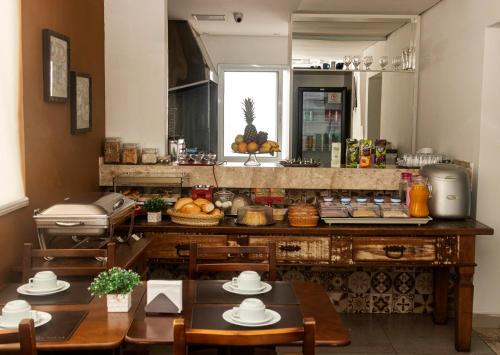 圣保罗雅布提卡巴酒店的厨房配有2张桌子和1个带食物的柜台