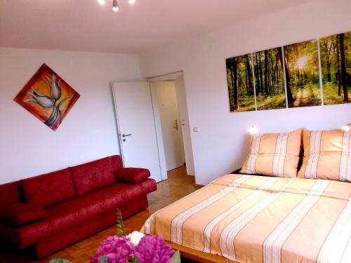 德累斯顿Helles Apartment mit Balkon am Großen Garten nahe Stadtzentrum的一间卧室配有一张床和一张红色的沙发