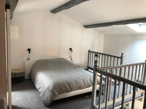 EsnandesPetite maison tout confort的一间卧室配有一张床和一个楼梯间