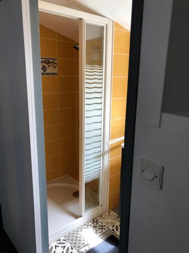 EsnandesPetite maison tout confort的浴室里设有玻璃门淋浴