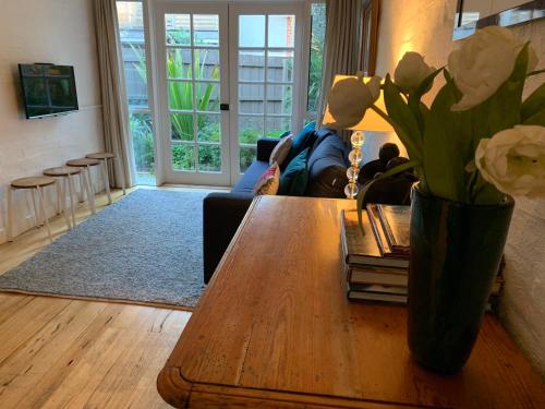 墨尔本Garden Cottage St Kilda的客厅配有鲜花桌