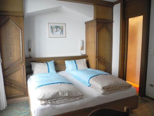 东蒂罗尔地区马特赖豪斯赫尔佐格公寓的一张带蓝色和白色枕头的床