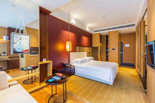 深圳深圳湾木棉花酒店的一间酒店客房,配有一张床和一台电视