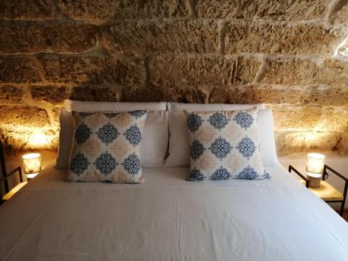 泰拉西尼B&B Sea Salt的一间卧室配有带枕头的床和砖墙
