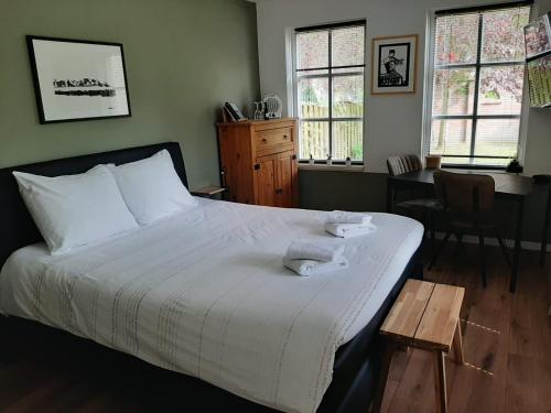 于尔克B&B De Reede的卧室配有床、桌子和窗户。