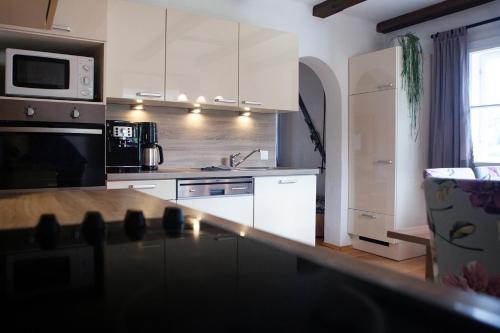 卡普伦可林吉尔度假屋的厨房配有白色橱柜和台面