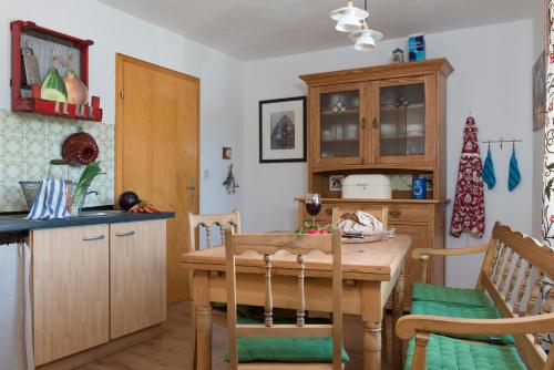 HasselbachFerienwohnung Stein mit Sauna的一间带木桌的厨房和一间餐厅