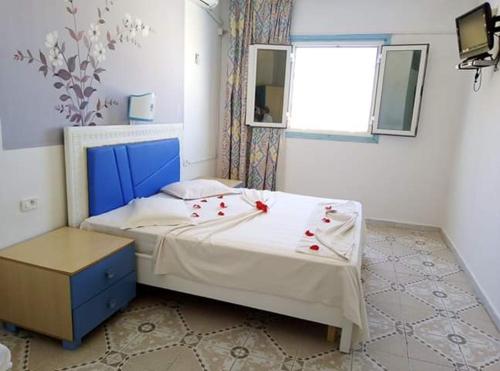 马赫迪耶Houria House Sable D'or的一间卧室,床上有红色的鲜花