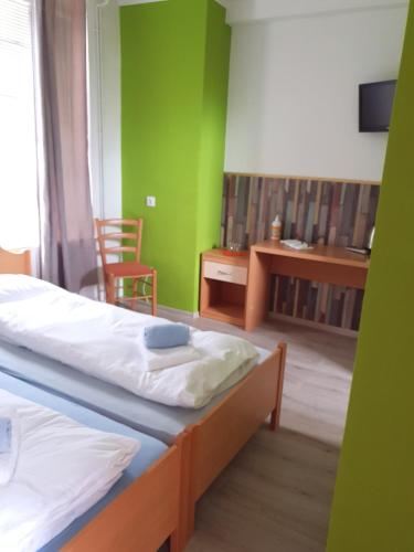 ŽirovnicaGuesthouse Osvald的一间卧室配有两张床、一张桌子和一把椅子