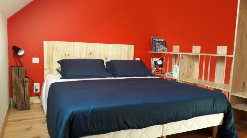 RévillonLE RELAIS的一间卧室设有一张红色墙壁的大床