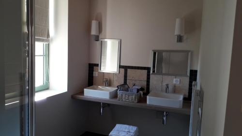 RévillonLE RELAIS的浴室设有2个水槽和镜子