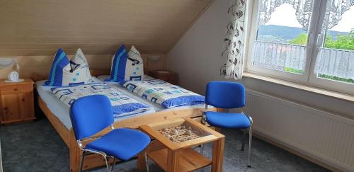 梅德巴赫Haus Gräben的一间小卧室,配有一张床和两把蓝色的椅子