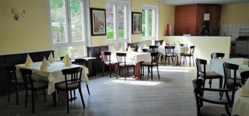 KindsbachLandhotel Schuff的餐厅设有白色的桌椅和窗户。