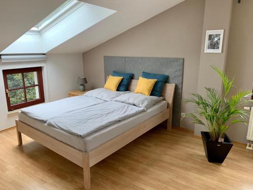莱比锡Charmante Dachgeschoss Wohnung的一间卧室配有一张带蓝色和黄色枕头的大床