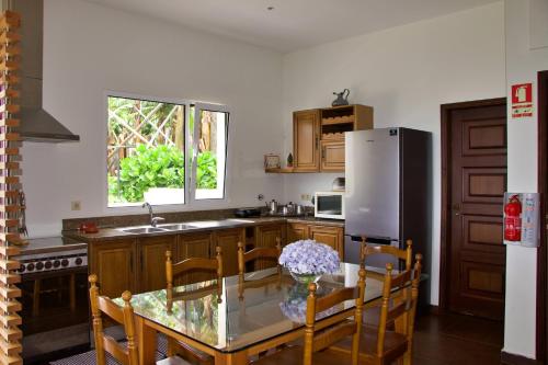 丰沙尔Quinta Tallinus的厨房配有玻璃桌和冰箱
