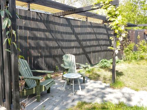 斯哈伦代克Finca Vrij的后院设有两张绿色椅子和一张桌子