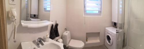 欧尔菲Ady Apartmanház的白色的浴室设有卫生间和水槽。