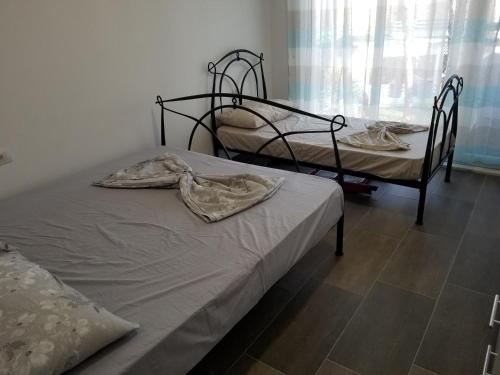 都拉斯Beach Veranda Home, Gjiri i Lalzit的一间卧室设有两张床和窗户。