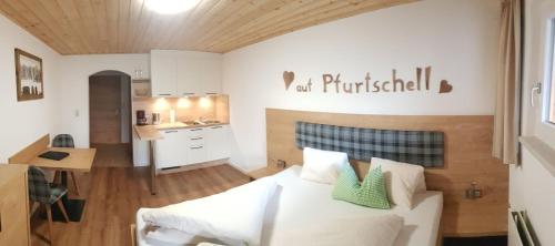 施图拜河谷新施蒂夫特Pfurtschell的一间带白色床的卧室和一间厨房