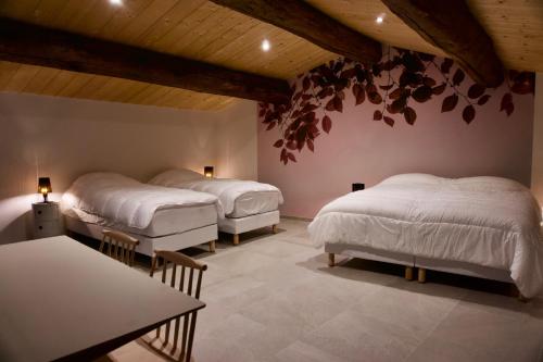 尚泰梅尔莱布莱Gîtes Du Mas de Surlan的一间设有两张床和一张桌子的房间