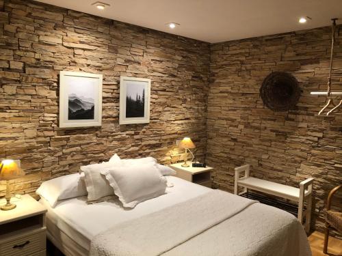 GarayoaHostal Arostegui的一间卧室设有一张大床和石墙