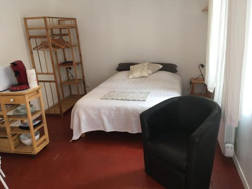 圣萨蒂尔La Bernache的一间卧室配有一张床和一张黑椅