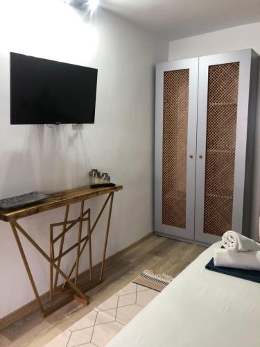 多亚马伊Casa Mediterana的卧室配有一张桌子,墙上配有电视