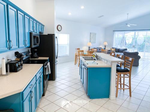 奥兰多Affordable Luxury Home Near Walt Disney World - Sunshine Villa at Glenbrook Resort, Orlando, Florida的一间设有蓝色橱柜的厨房和一间客厅