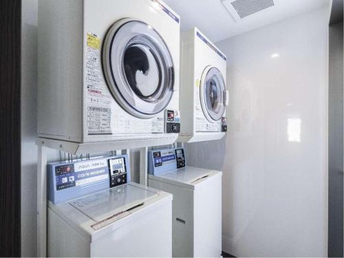 高山Hotel Wing International Hida Takayama的洗衣房配有2台洗衣机和1台洗衣机
