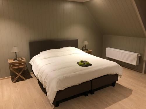 瓦勒海姆B&B De Dulle Koe的卧室配有一张白色大床,上面有弓