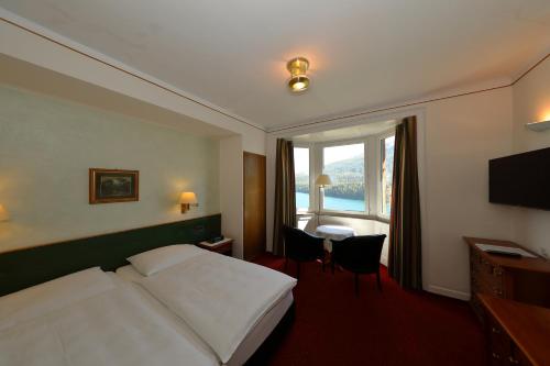圣莫里茨索尔达纳拉酒店的配有一张床、一张书桌和一扇窗户的酒店客房