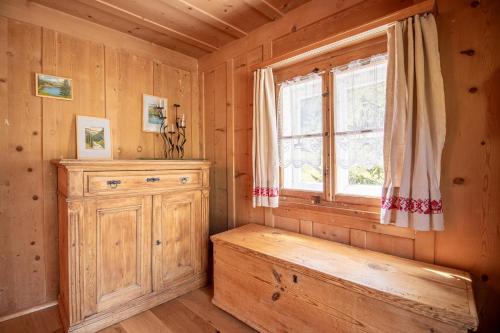 阿罗萨Chalet Büdemji by Arosa Holiday的小木屋内的一个房间,设有长椅和窗户