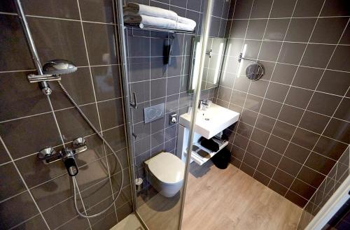 布雷斯特基里亚德布雷斯特酒店的带淋浴、卫生间和盥洗盆的浴室