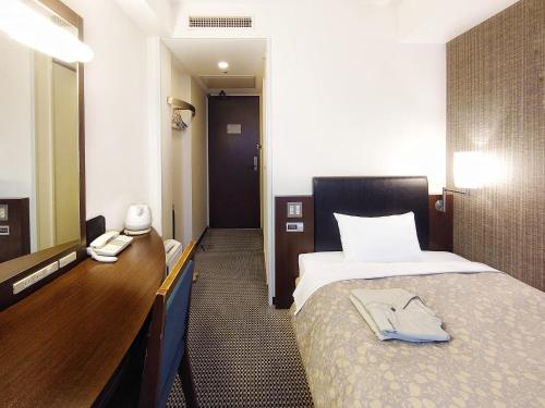 高冈市高冈曼藤伊可玛酒店的酒店客房配有床、梳妆台和镜子