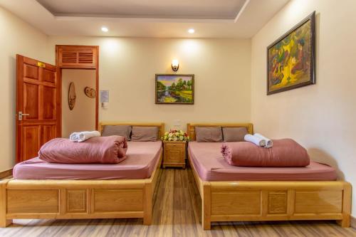 大叻Anh Trang Homestay的客房内的两张床和红色枕头