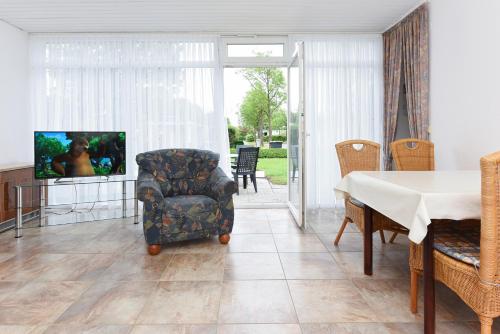 贝塞尔Ferienhaus Nordwind的客厅配有电视、椅子和桌子