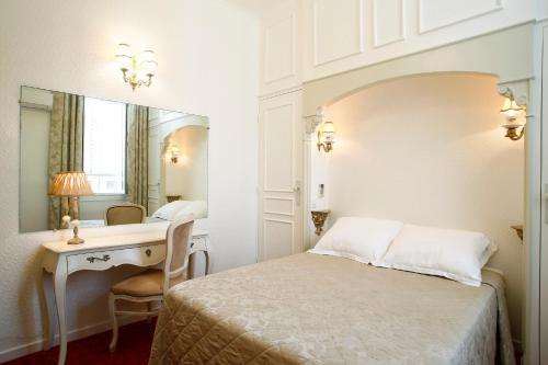 卡尔维木兰花酒店的一间卧室配有一张床、一张书桌和一面镜子