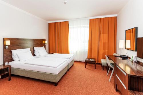 帕尔杜比采欧元酒店的配有一张床和一张书桌的酒店客房