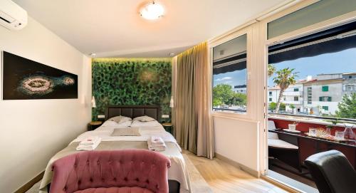斯普利特Il Giardino Luxury Rooms & Suites的酒店客房设有一张床和一个大窗户