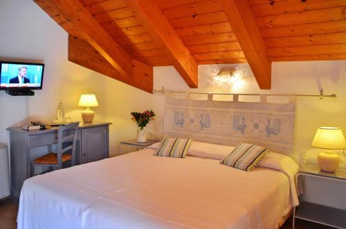 博萨佩西赫特乡村之家旅馆的卧室配有白色的床和电视。