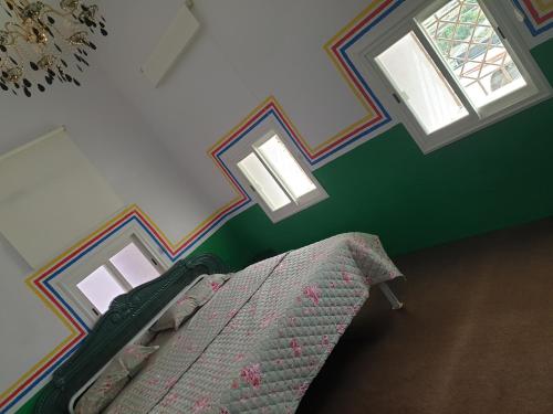 Al Assanمنزل ريفي بناء حجري的一间卧室设有一张床和两个窗户。
