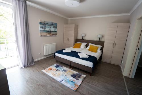 斯维诺乌伊希切Apartament Feniks 12 - 63 m2的一间卧室设有一张床和一个大窗户