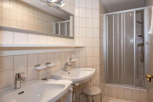 蒂罗尔-泽费尔德兰德海大公寓的白色的浴室设有水槽和镜子