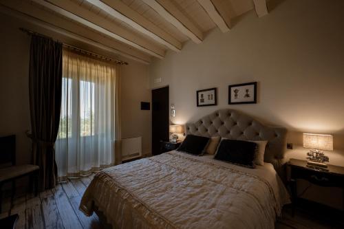 切法卢Donna Carolina Luxury rooms的一间卧室设有一张大床和一个大窗户