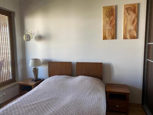 科沃布热格Olympic Park Apartament A403的卧室配有一张床,墙上挂有两张照片