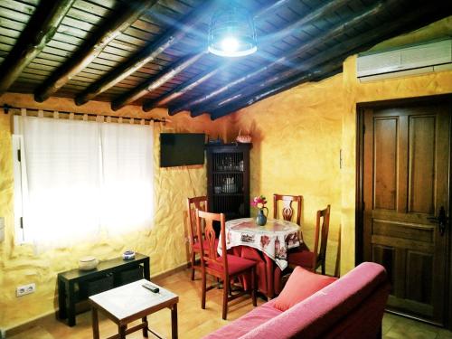 米兰达德尔卡斯塔尼亚尔Casa rural La Villa的客厅配有桌子和粉红色的沙发