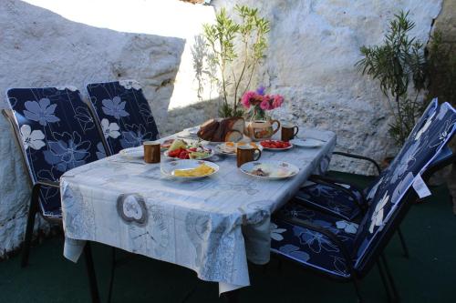诺茨瓦约Kakukkfu Barlang-Vendeghaz的一张桌子,上面放着食物和鲜花