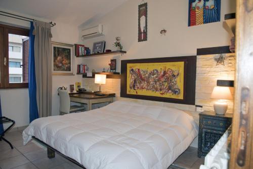 奥尔比亚Guesthouse Nuvole的卧室配有一张白色大床和一张书桌